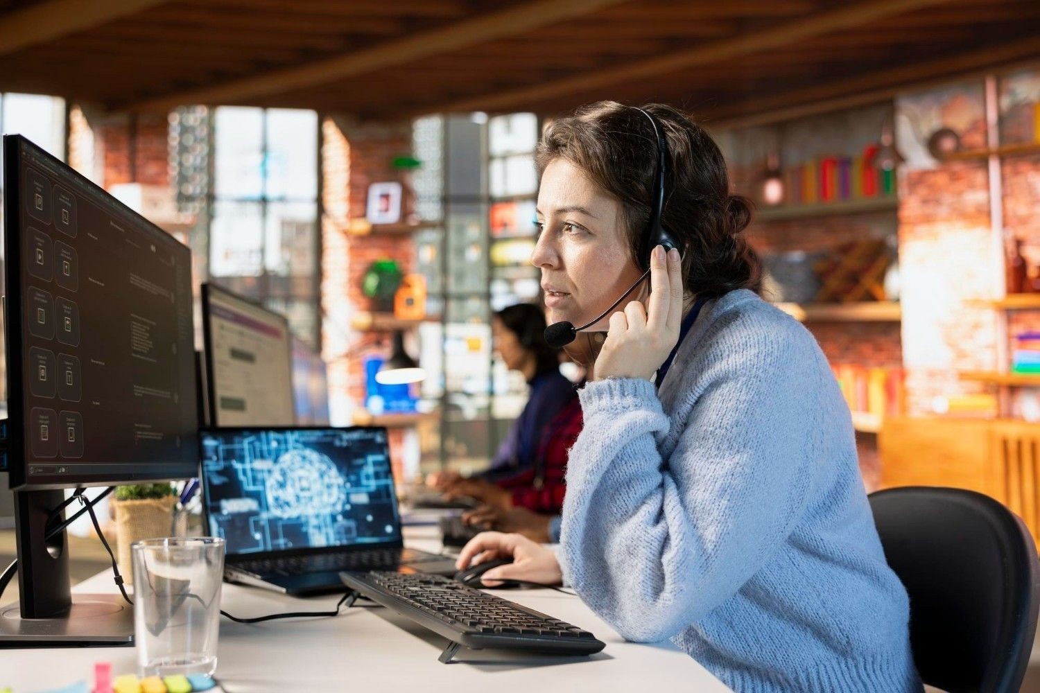 Customer support agent with headset working at a computer station