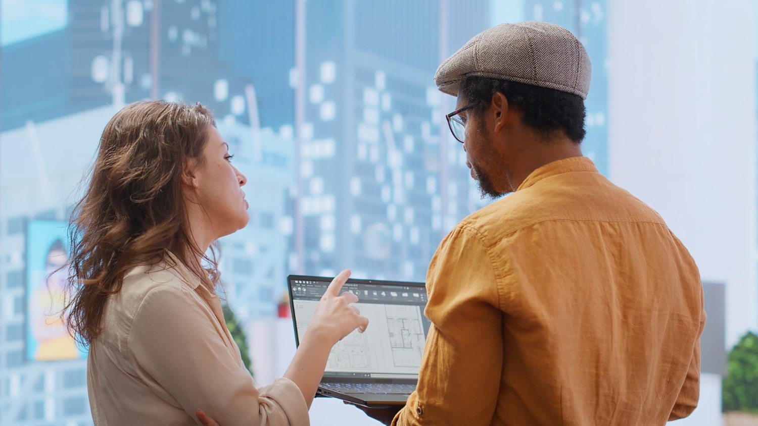 Architects discussing floor plans on a laptop